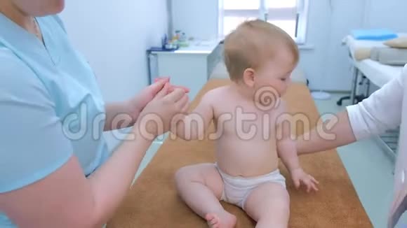 专业医生按摩师在诊所为微笑的婴儿做按摩视频的预览图