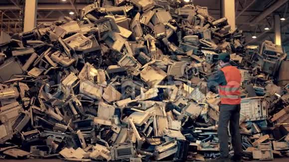 电子垃圾回收厂垃圾填埋场检查员把垃圾扔进一堆视频的预览图