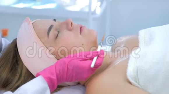 美容医生用刷子在美容诊所妇女脸上敷面膜视频的预览图