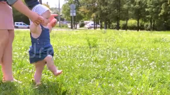 妈妈学习女婴走路第一步在公园赤足露腿侧视视频的预览图