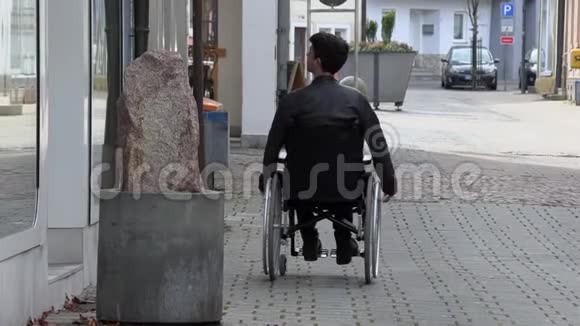 一个坐轮椅的人在市中心检查橱窗视频的预览图