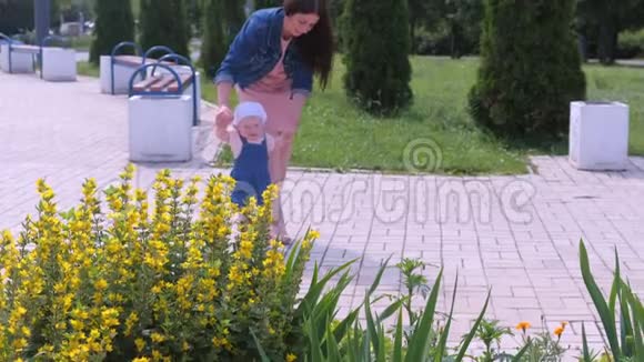 妈妈正和女儿在公园散步宝贝女儿牵着她的手学习去视频的预览图