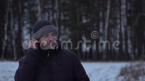 冬天中年人用耳机听音乐视频的预览图