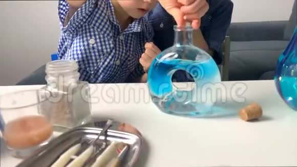孩子们小学的男孩在玻璃瓶中用可乐液体进行化学实验这是一个科学的概念4公里视频的预览图