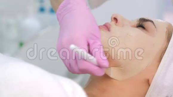 美容师在美容诊所给女性客户面部和颈部敷面膜视频的预览图