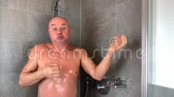 有趣的秃头中年男子洗澡表现出演奏乐器视频的预览图