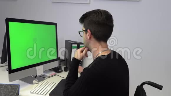 坐轮椅的商人在电脑前工作的年轻人视频的预览图