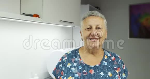 幸福的老年妇女在医院看着摄像机笑着露出洁白的牙齿的画像视频的预览图
