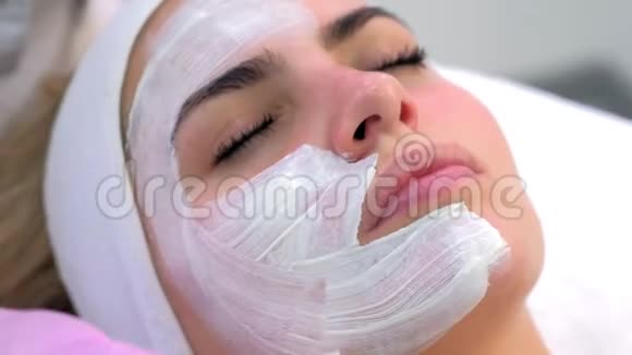 美容医生正在美容诊所给女性客户敷上白色面膜视频的预览图