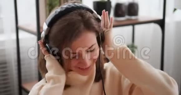 女人在耳机上听音乐视频的预览图