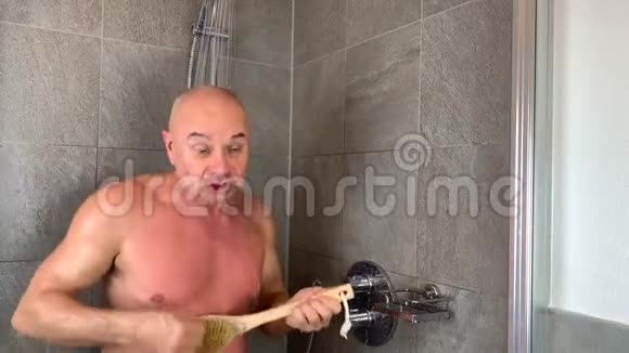 有趣的秃头中年男子洗澡富有表现力地描绘了弹吉他视频的预览图