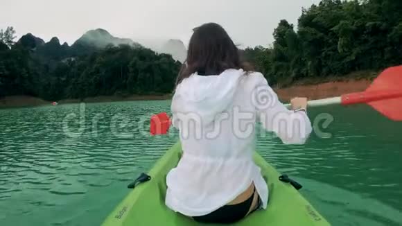 一个女孩在河上骑皮艇时使用划桨视频的预览图