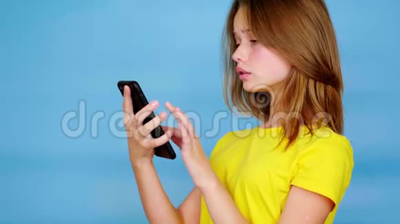 穿黄色t恤的少女在智能手机上使用滑动触摸屏视频的预览图