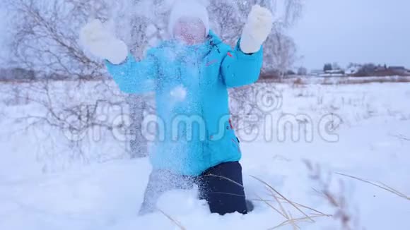 女孩走在冬天的树林里扔雪微笑笑在新鲜空气中游走视频的预览图