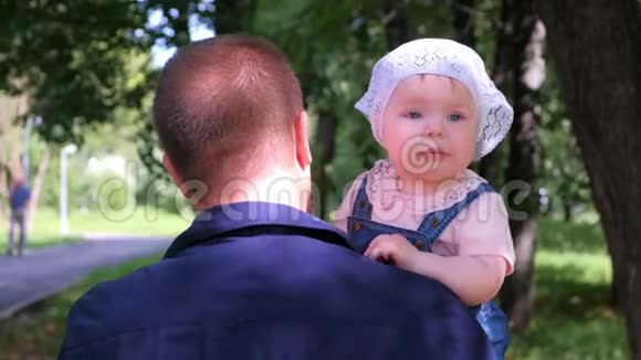 小爸爸抱着宝贝女儿在城市公园家人宝贝看着镜头视频的预览图