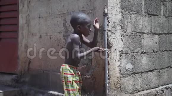 非洲黑人小男孩在水龙头边喝酒的慢镜头视频的预览图