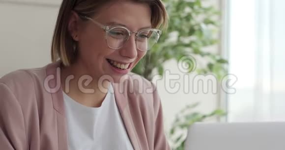 快乐女商人在办公室笔记本电脑上工作视频的预览图