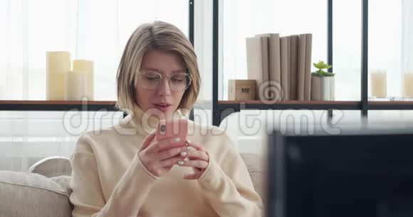 女人在家里用手机看电视视频的预览图