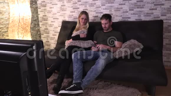一个男人和一个女孩坐在大厅里在电话里给对方发信息视频的预览图