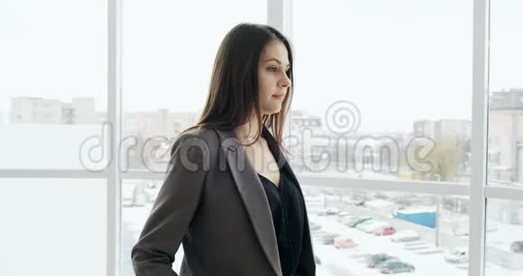 女商人交叉双臂微笑的肖像漂亮的女经理站在办公室的窗户附近视频的预览图