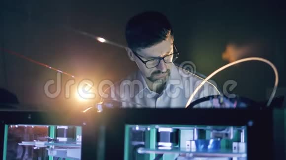 男性专家正在仔细观察一个3D打印机视频的预览图