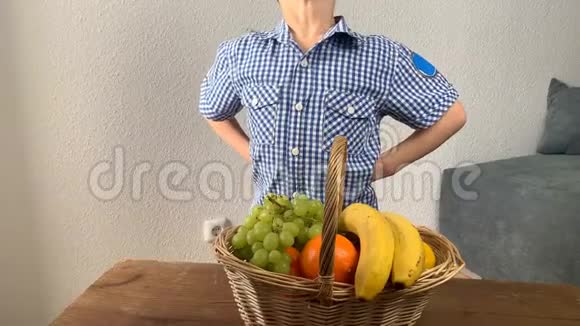 小孩站在木桌上的一篮子水果和蔬菜前视频的预览图