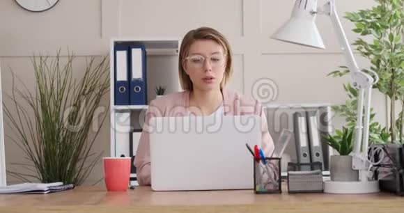 女商人在办公室写笔记和使用笔记本电脑视频的预览图