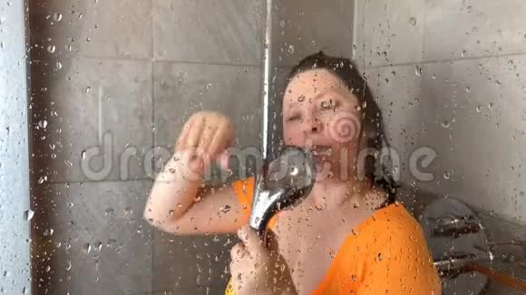 穿着橙色T恤的中年妇女洗澡时很开心视频的预览图