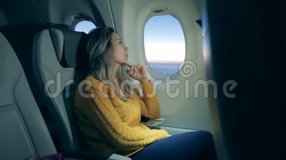 一位女士正在飞机窗口看日出视频的预览图