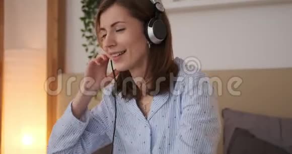 快乐的女人在耳机上听音乐视频的预览图