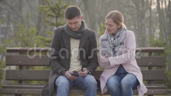 在智能手机上看了他的留言后一位成年白种人女人离开了悲伤的年轻人肖像丈夫或丈夫视频的预览图