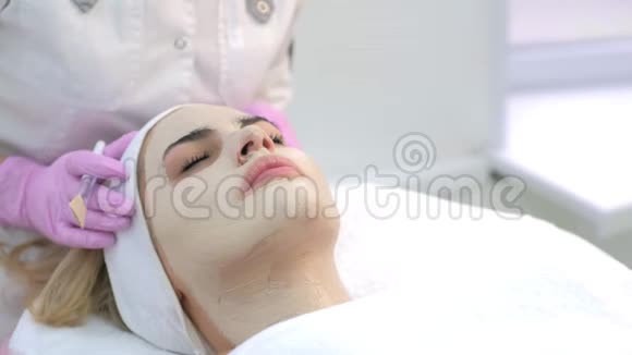 美容医生在美容诊所为女性客户面部敷面膜视频的预览图