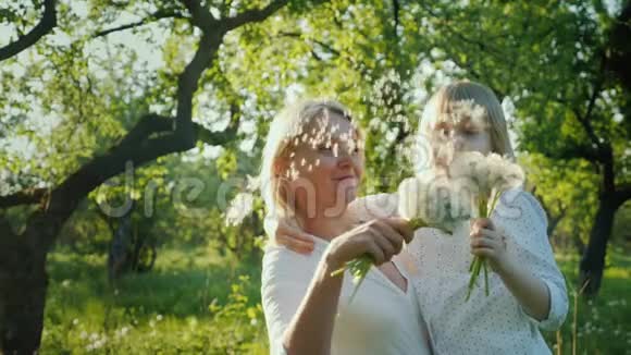 妈妈和女儿一起玩得很开心玩一束吹蒲公英的种子视频的预览图