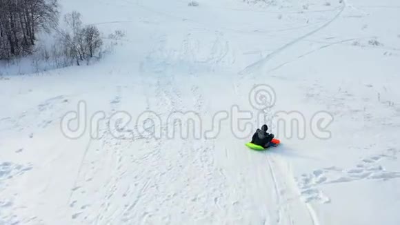一个孩子在雪山上骑马和玩耍慢动作雪的冬季景观户外运动视频的预览图