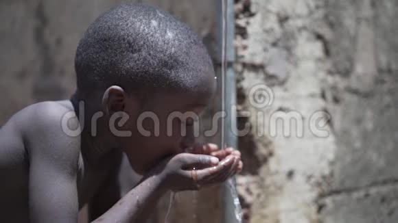 卫生标志小非洲黑人男孩从马里巴马科的自来水中喝淡水视频的预览图