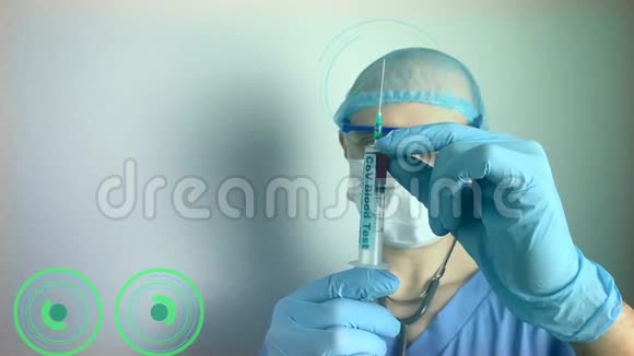 穿着蓝色制服戴着保护面具的听诊器戴着眼镜的男性医生看着一支带血的医用注射器视频的预览图