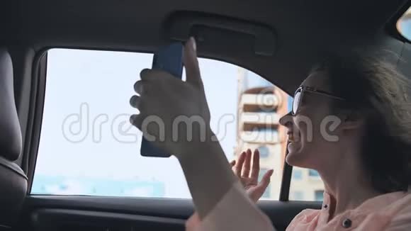 这个女孩正在用一部来自迪拜的电话从一辆汽车上直播视频的预览图