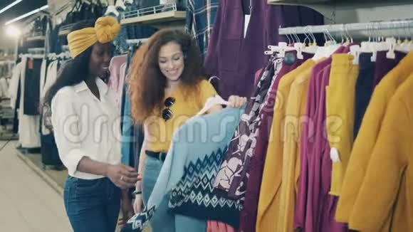 快乐的女士们正在商店里翻阅衣服视频的预览图