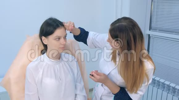 美容师在涂饰前对妇女眉毛进行铅笔涂饰视频的预览图