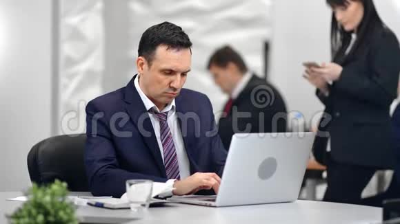 时尚忙碌的男人老板在工作场所用电脑打字同事背景视频的预览图