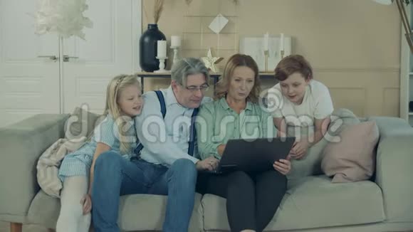 爷爷奶奶和孙子在玩手提电脑视频的预览图