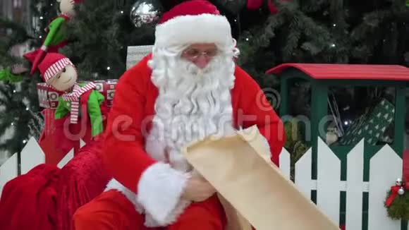 坏圣诞老人拿着一袋礼物坐在购物中心上大呼小叫视频的预览图