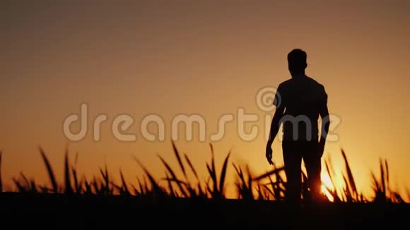 一个年轻人喜欢新鲜的空气欣赏日落他把双手放在脑后视频的预览图