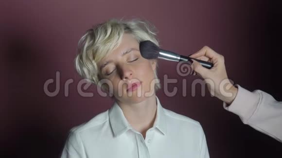 化妆师将化妆应用于模特的面部视频的预览图