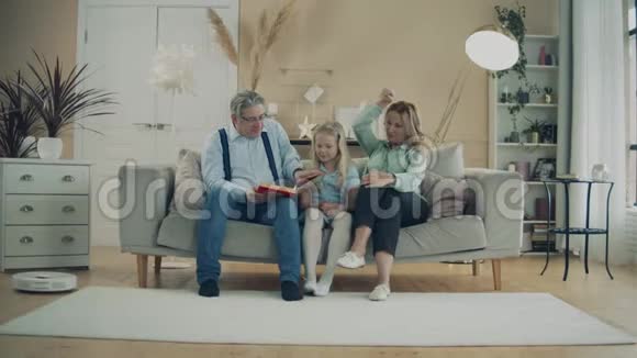 小女孩和爷爷奶奶一起读一本书视频的预览图