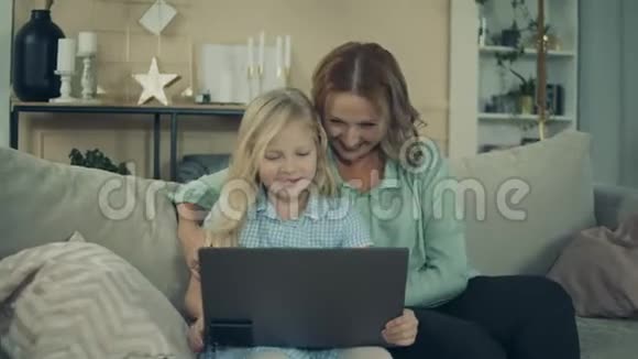 一个女孩和她奶奶在玩手提电脑视频的预览图