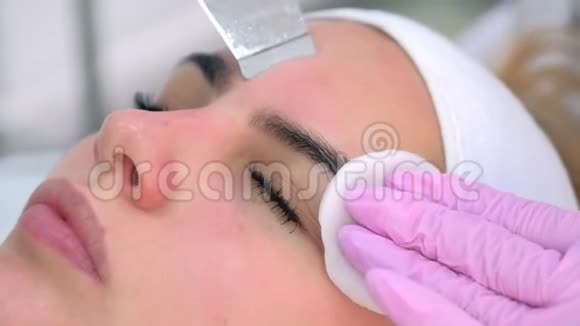 美容师为临床上的年轻女性做超声清洗手术视频的预览图