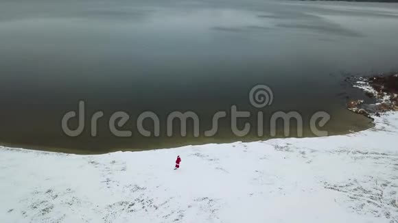 圣诞老人带着一袋礼物沿着雪的湖岸走圣诞老人从疲劳中掉下来掉了一个视频的预览图