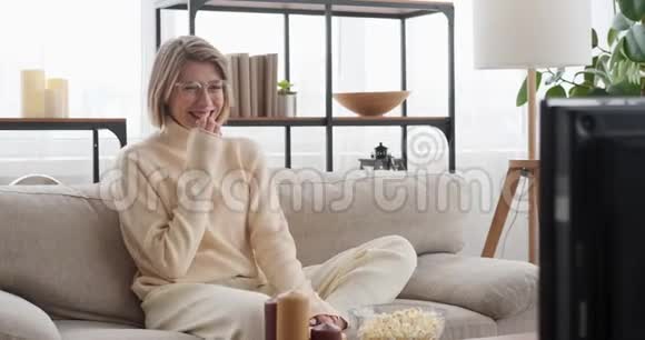 女人在家看电视时笑视频的预览图