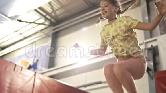 学龄可爱的女孩在蹦床上跳孩子很快乐视频的预览图